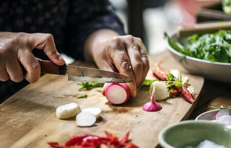 Hands using a knife chopping turnips