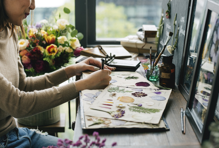 Foto de Woman Hand Writing Dry Flowers Plants Collection Details - Imagen libre de derechos