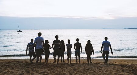 Foto de Rear view of diverse friends at the beach together - Imagen libre de derechos