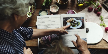 Senior woman reading a cooking book