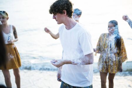 Group of diverse friends enjoying sparklers at the beach together
