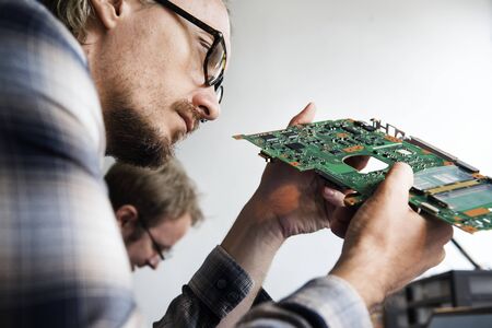 Side view of technician working on computer mainboard