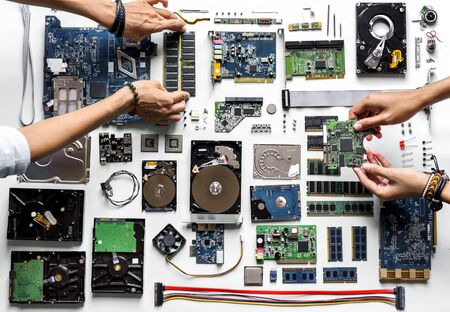 Aerial view of hands with computer electronics parts on white background