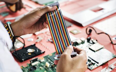 Clsoeup of hands holding computer breadboard flat wires cables