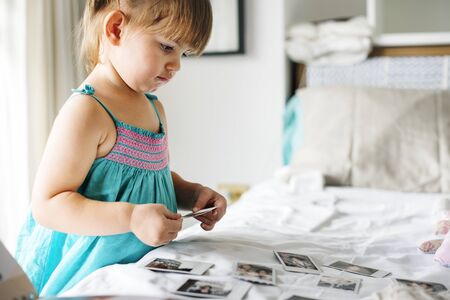 Little girl looking her family photo in album