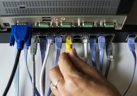 Hand holding a LAN cable to the hub