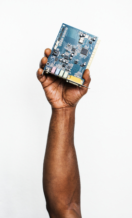 Hand holding computer motherboard isolated on white