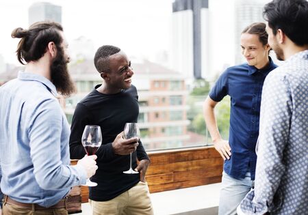 Man standing holding a wine glass talking