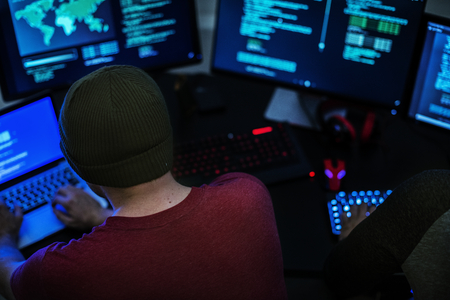 Rear view of hacker man working on computer