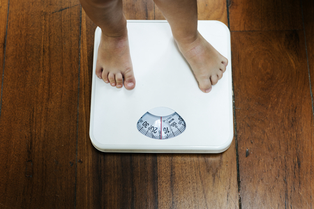 Closeup of kid legs on weight scale