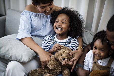 Young cheerful black kid with family