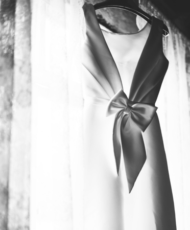 Foto de Closeup of White Wedding Dress Hanging by the Window Grayscale - Imagen libre de derechos