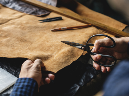 Craftsman cutting into a hide