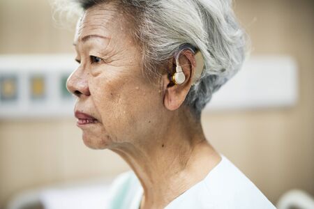 An elderly woman with hearing aid