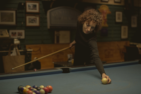 Woman playing pool at a bar