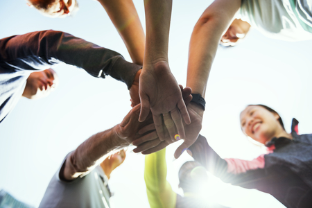 Diverse people joined hands together
