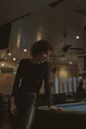 Woman playing pool at a bar