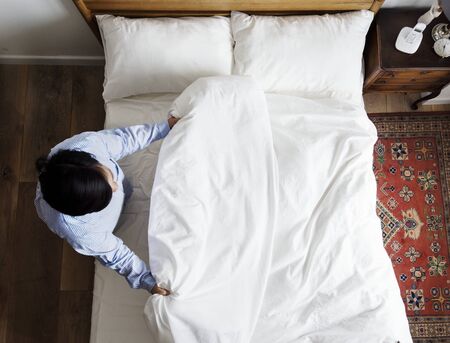 Woman making her bed in the morning