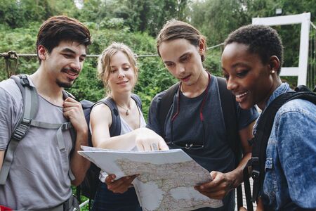 Group of friends looking at a map together travel and teamwork concept