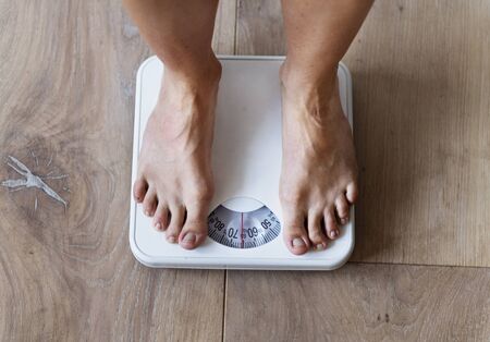 Pregnant woman weighing herself