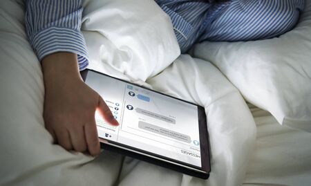 A woman using a tablet in bed