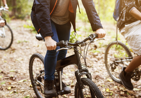 Group of friends ride mountain bike in the forest together