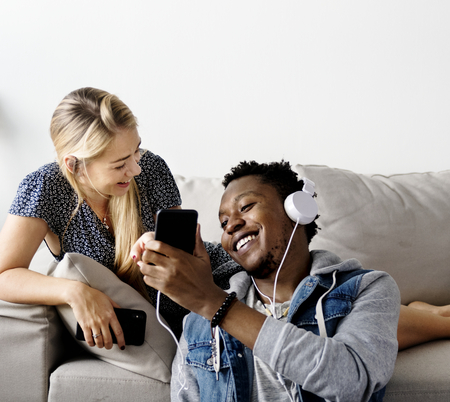 Interracial couple sharing music at home love, leisure and music concept