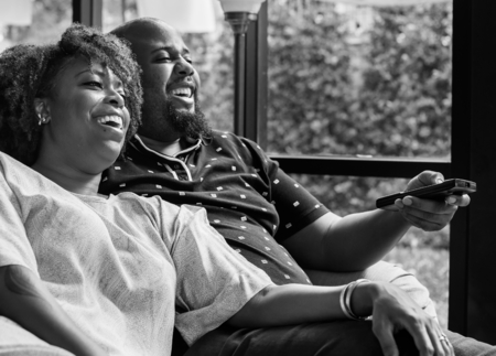 Cheerful couple watching TV together