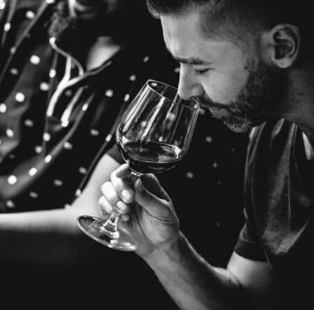 Man tasting red wine with friends