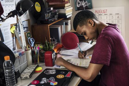 Teenage boy in a bedroom doing work stressed out and frustrated
