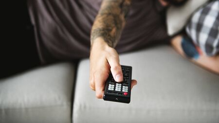 Man lying on a couch watching tv