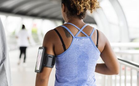 Healthy woman exercising while using technology