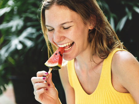 Caucasian woman eating watermelon in summertime