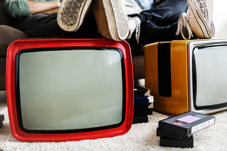 Two man sitting and two retro television