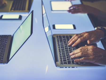 Hand on a laptop working at cyber space table