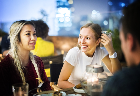 Friends having a dinner together at a rooftop bar