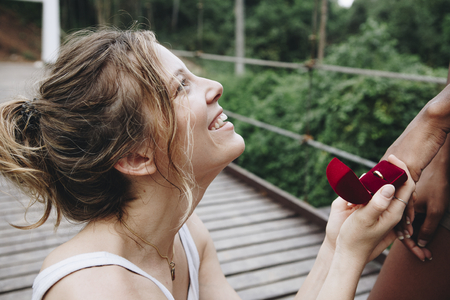 Woman proposing to her happy girlfriend outdoors love and marriage concept