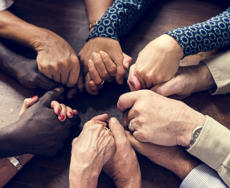 Group of diverse hands holding each other support together teamwork aerial view
