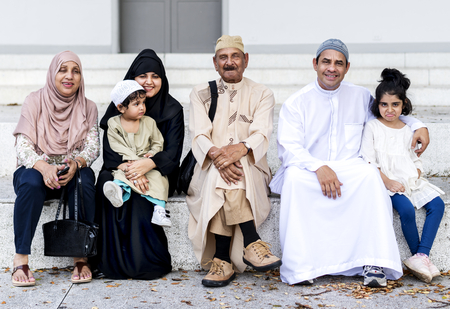 Muslim family sitting together outdoors