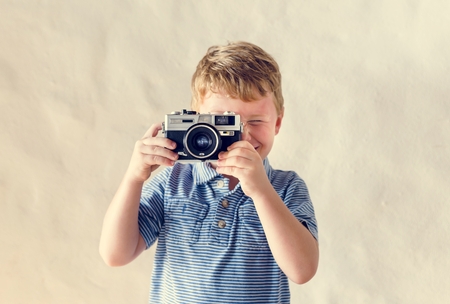 Caucasian boy playing with a camera