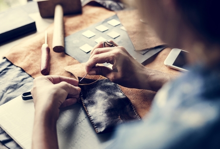 Closeup of craftsman sewing leather handicraft