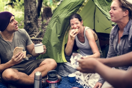 Group of diverse friends camping in the forest