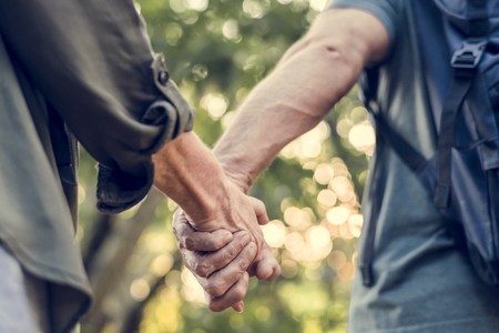 Elderly couple holding hands in the forest