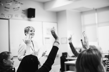 Photo pour Students with their hands up responding to their teacher - image libre de droit