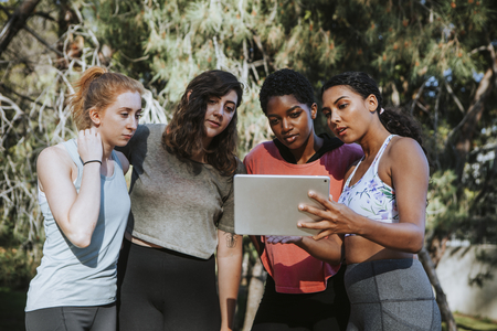Group of active women looking at a digital tablet
