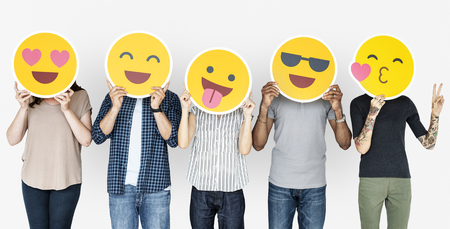 Diverse people holding happy emoticons