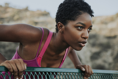 Woman stretching against a park bench