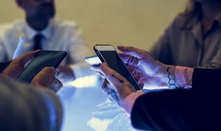 People holding smartphone in a meeting