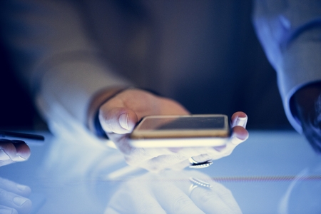 Photo pour Hand holding smartphone in a meeting - image libre de droit