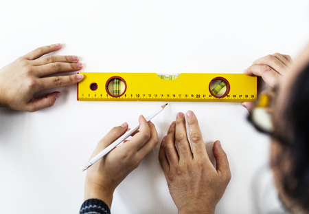 Asian couple measuring the wall